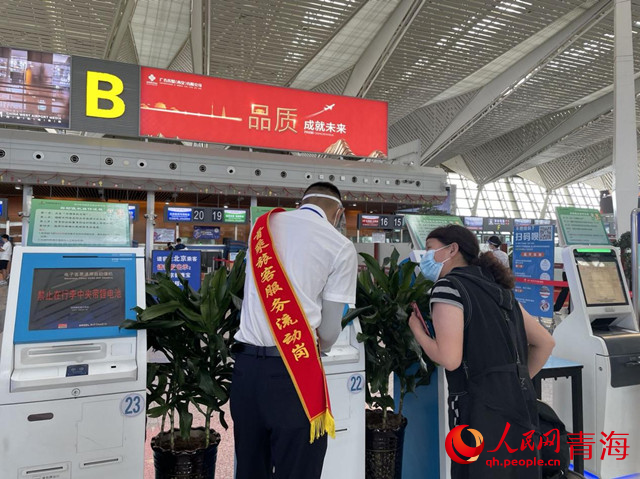 首乘旅客服務(wù)流動崗工作人員為旅客提供幫助。人民網(wǎng) 況玉攝