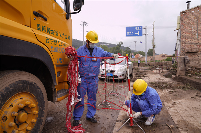 應(yīng)急保電人員正在為電源車裝設(shè)網(wǎng)圍欄。王國棟攝