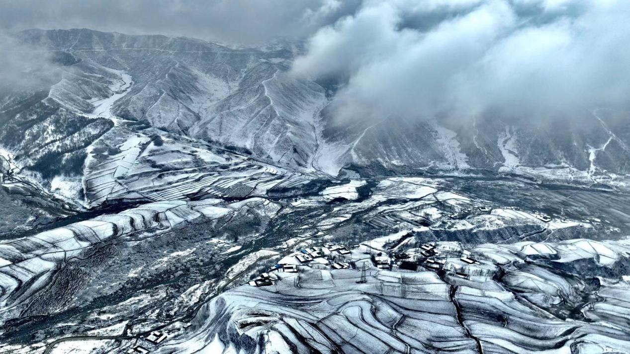 遠處云霧繚繞，近處村落零星，雪后化隆宛如一幅水墨畫。李玉峰攝