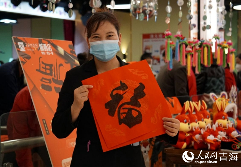 市民領(lǐng)取到義寫的春聯(lián)。人民網(wǎng) 況玉攝