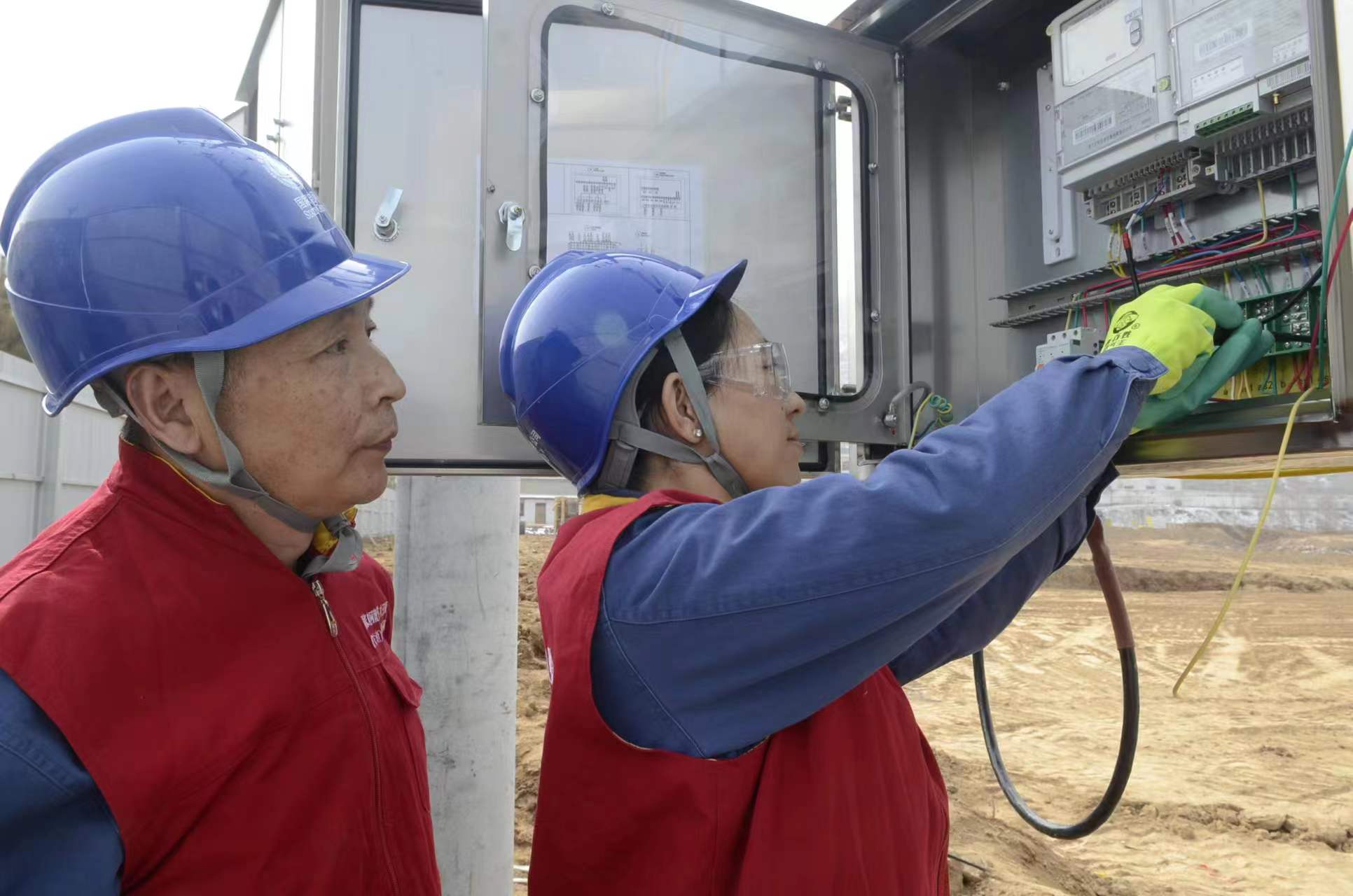 國家電網(wǎng)青海電力三江源（海東營銷）共產(chǎn)黨員服務(wù)隊隊長穆萍和隊員朱向陽進(jìn)行裝表接電作業(yè)，成功解決了青海省海東市民和縣川口鎮(zhèn)紅衛(wèi)村老年養(yǎng)護(hù)院建設(shè)工程施工用電問題。（馬彩虹 攝）