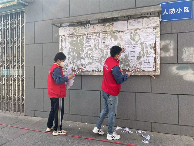 青年志愿者鏟除小廣告。滕萌攝