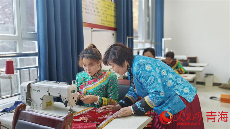 文青花正在指導繡娘做刺繡。人民網(wǎng)記者 張莉萍攝