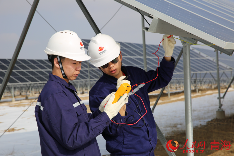 塔拉灘的光伏光熱園區(qū)內(nèi)，工作人員正在測量光伏組串開路電壓及電流數(shù)據(jù)。人民網(wǎng) 馬可欣攝
