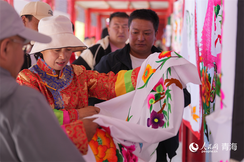 欣賞土族阿姑刺繡作品。人民網(wǎng) 陳明菊攝