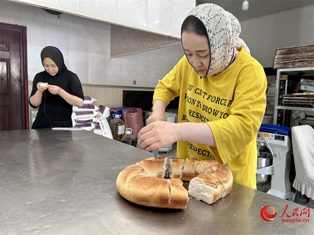 饃饃店老板切割黃南饃饃。人民網(wǎng)記者 陳明菊攝