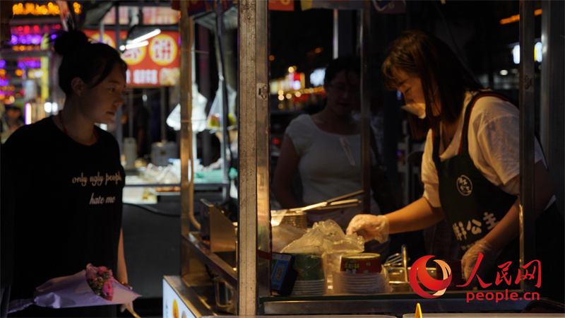 游客在夜市購(gòu)買(mǎi)小吃。人民網(wǎng)記者 甘海瓊攝