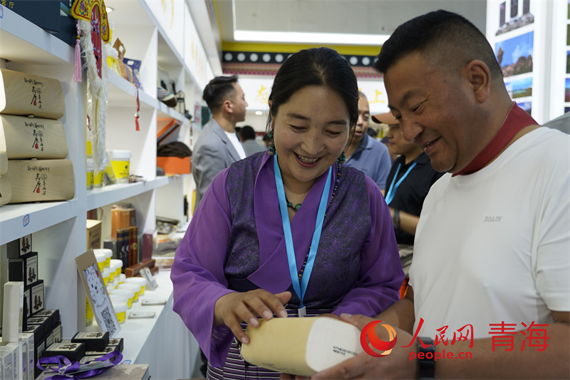 參展商向游客介紹相關(guān)商品。人民網(wǎng)記者 甘海瓊攝