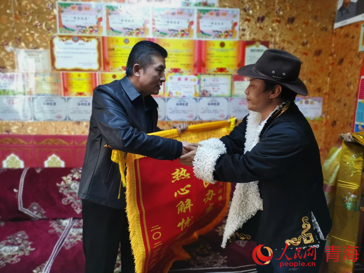 扎西東智（右）為董暉（左）送上錦旗。人民網(wǎng) 況玉攝