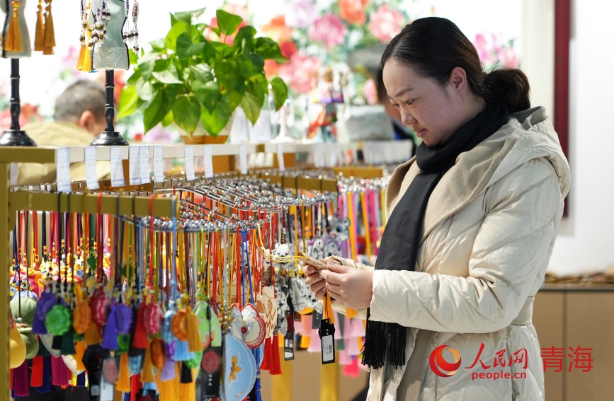 參觀者選購(gòu)青繡掛件。人民網(wǎng)記者 甘海瓊攝