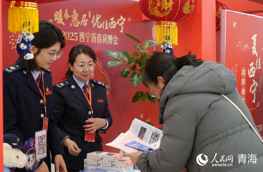 稅務(wù)部門工作人員向購房群眾介紹稅費政策。人民網(wǎng)記者 甘海瓊攝