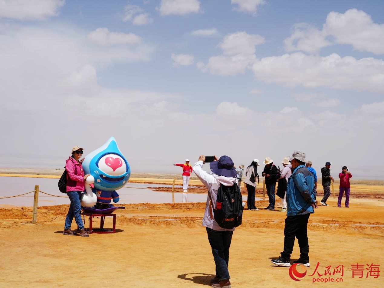 游客與艾肯泉文創(chuàng)玩偶合影。人民網(wǎng) 況玉攝